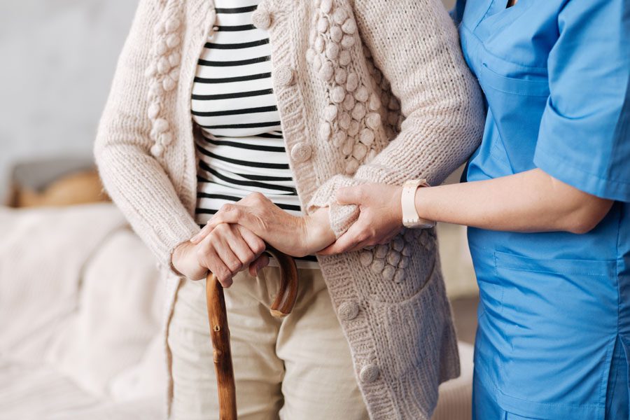 Long Term Care Insurance - Nurse Helping a Woman Walk