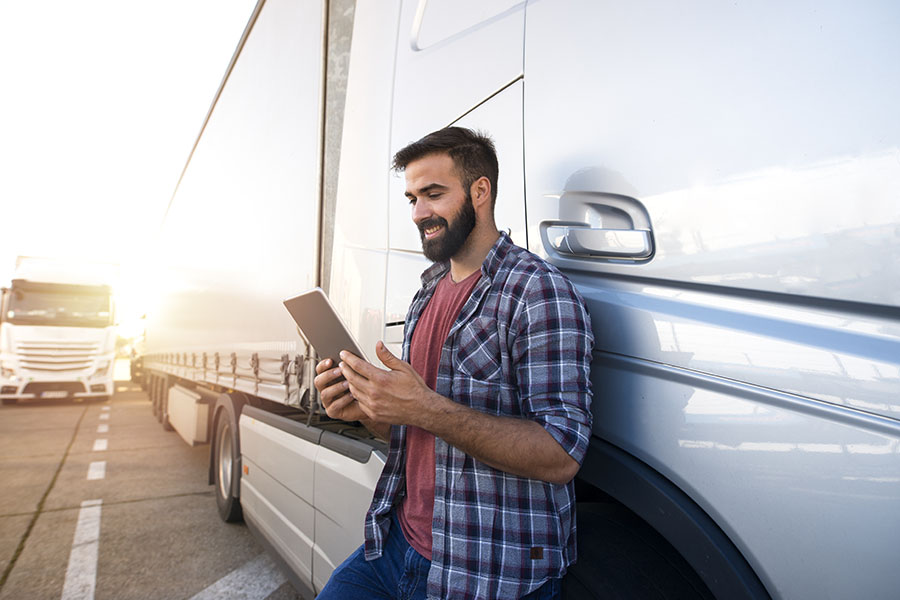 Blog - Truck Driver Standing Next To Truck Using Tablet