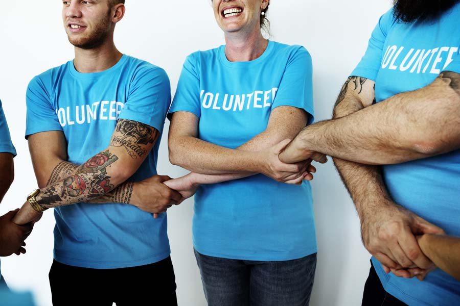 Non-Profit Insurance - Volunteers Holding Hands and Embracing