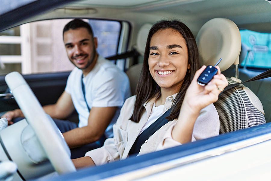 Specialty Insurance - Young Hispanic Couple Driving Auto at the City